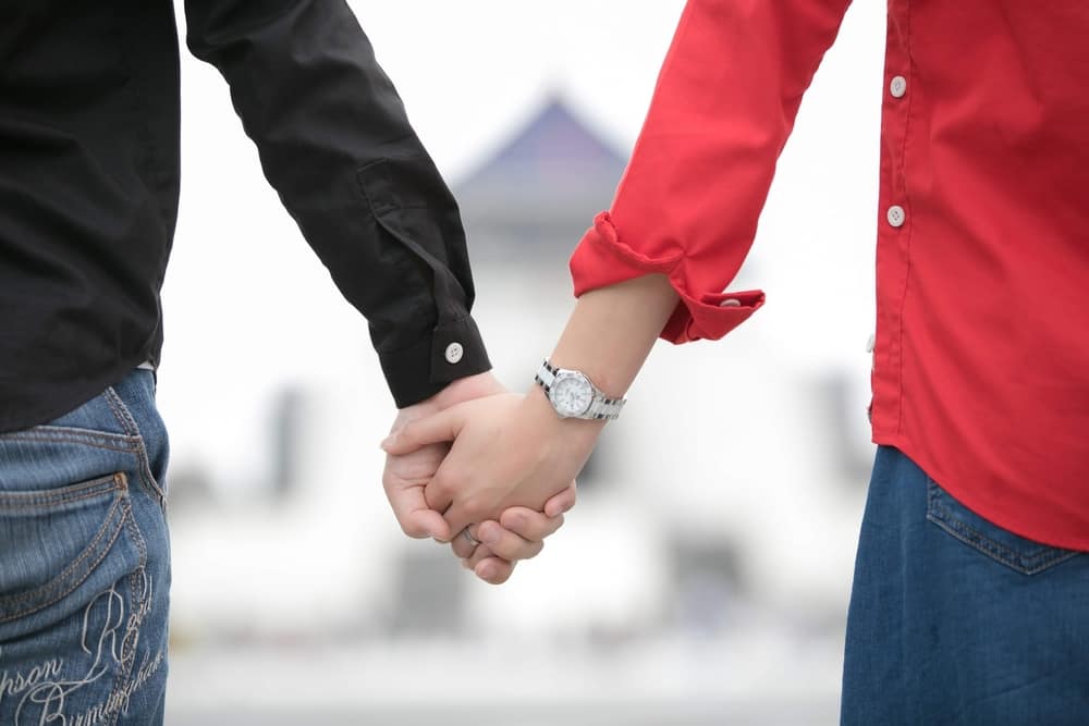 マッチングアプリでの出会いを経て幸せな関係を築いた男女が手を繋ぐ様子