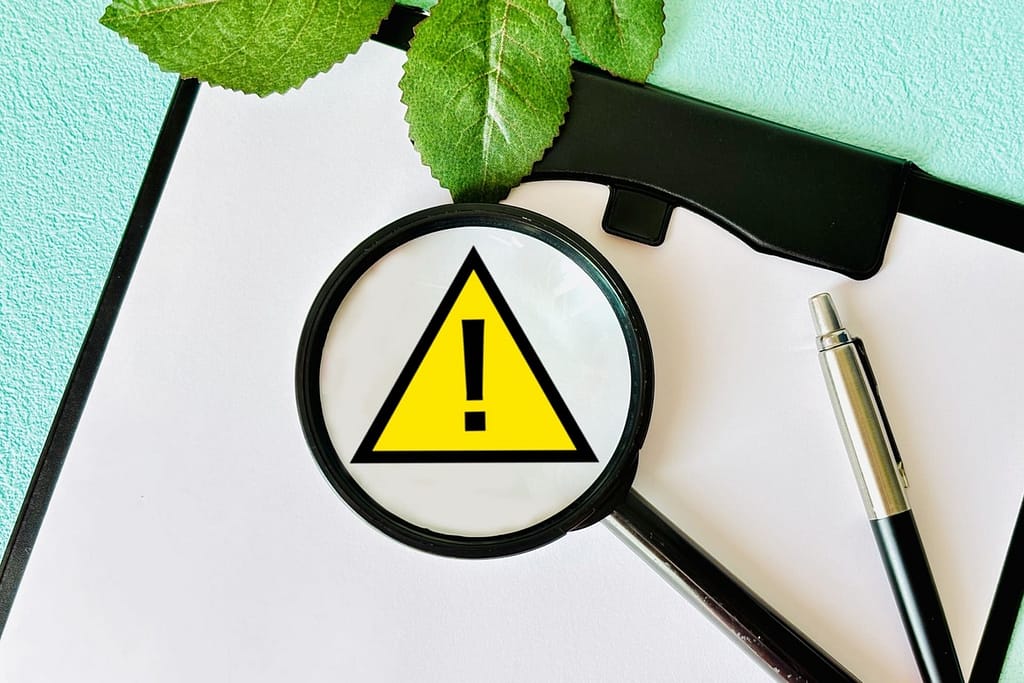 マッチングアプリでの追いメッセージのリスクを象徴する、虫眼鏡の中の警告マークのイメージ画像。